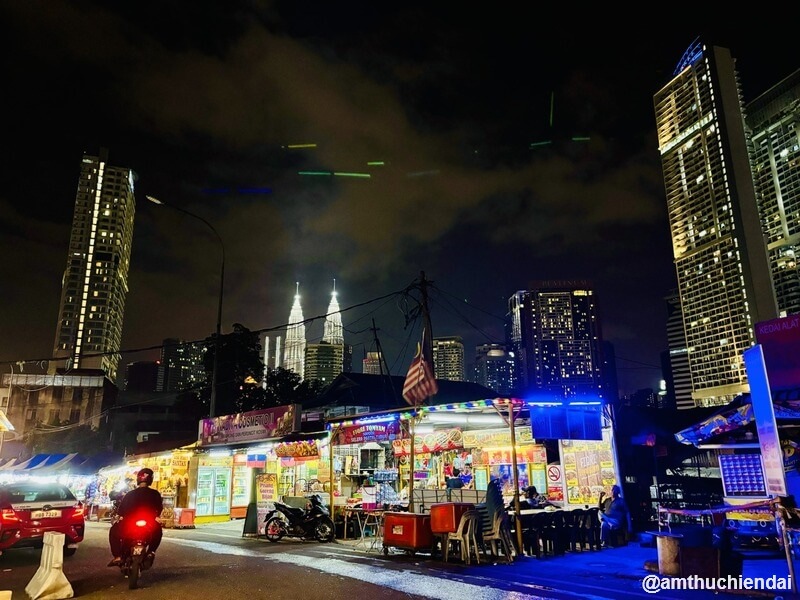 Những quán ăn đường phố dọc chợ Chow Kit - nền phía sau là tháp đôi Petronas
